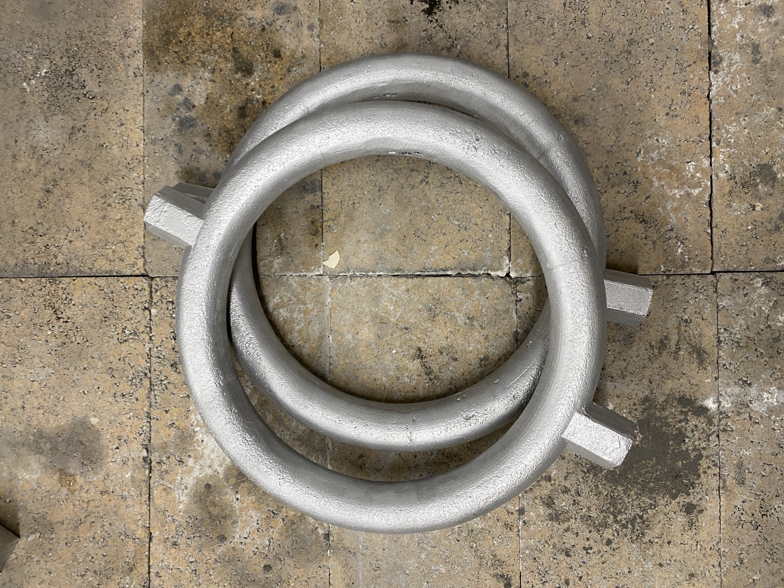 Two finished aluminum cast rings stacked on a stone surface.