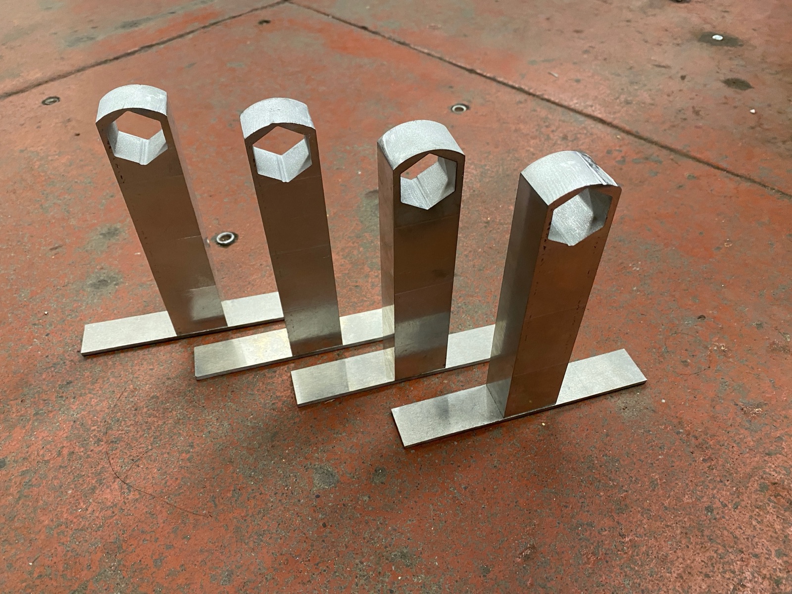 Four finished legs with baseplates attached, lined up.