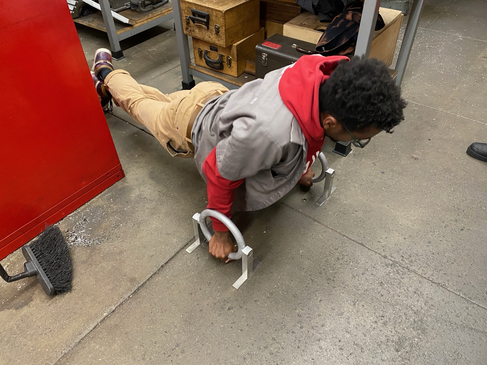 A course assistant doing a push-up on the Ringallets in the workshop.